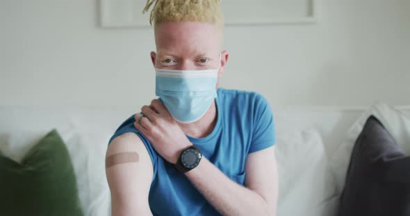 Happy albino african american man with dreadlocks and a plaster after vaccination alt