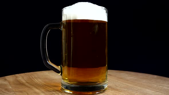 Glass of beer on a black background. alt