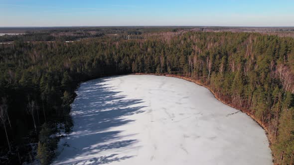 View from the top of the Latvian lake in the Jurmala region, the lake is icy and frozen covered