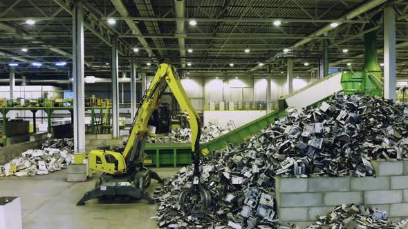 Junkyard Unit with a Loader Grabbing and Relocating Rubbish. Recycling Industry Concept, Plastic alt