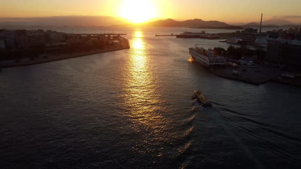 Drone View of a Small Barge Leaving the Port of Piraeus in Athens at Sunset