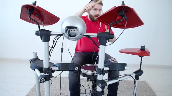 Concept of Hobby and Music Making Young Man Playing Drums at Home or in a Recording Studio alt