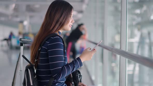 Young traveler woman use smartphone while waiting at airport