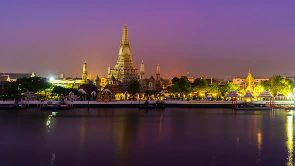night to day time lapse of Wat Arun Temple with Chao Phraya river in Bangkok, Thailand alt