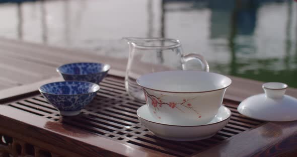 Faceless Woman Pouring Hot Water Into Teapot Preparing Chinese Tea Ceremony Near Water Slow Motion