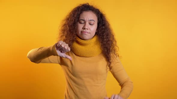 Young Pretty Woman Standing on Yellow Studio Background Expressing Discontent alt