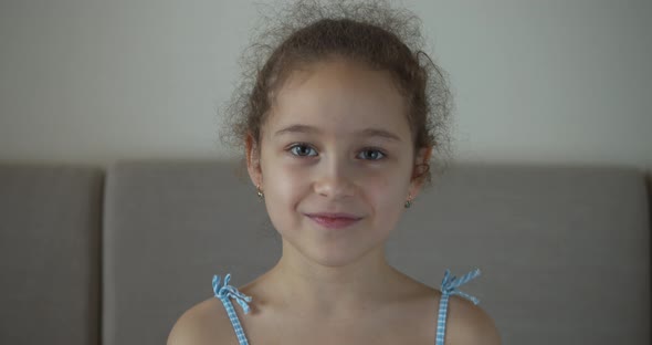 Portrait Funny Little Girl Smiling Chil Looking at Camera Are Sitting on the Couch at Home Cute Kid alt