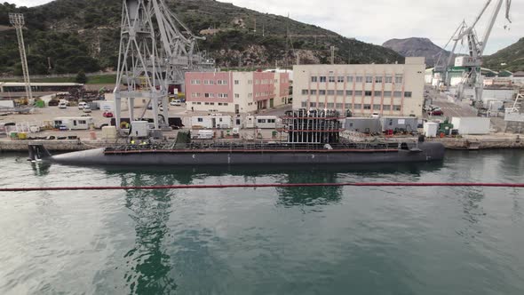 Submarine in dock undergoing maintenance, Cartagena, Spain; aerial pan