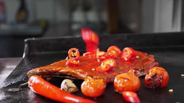 Chili Pepper Falls Onto Ribs with Vegetables Roasts on the Grill Slow Motion