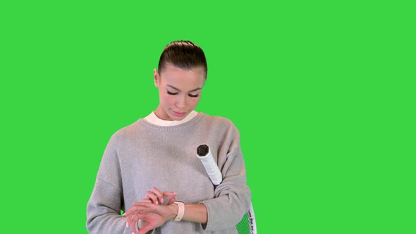 Girl Using Modern Smart Watch While Walking on a Green Screen Chroma Key alt