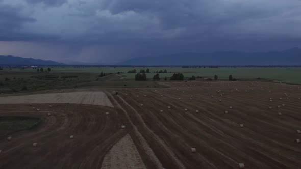Farm worker on agriculture fields in Altai under thunderstorm sky