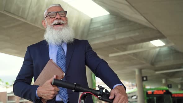 Senior business man going to work with electric scooter around  city center alt
