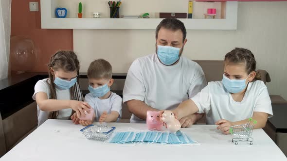 Dad and Children in Medical Masks Take Coins Out of Piggy Banks
