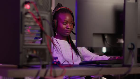 Handheld Shot of African American Streamer Talking on Headset While Online Playing First Person alt