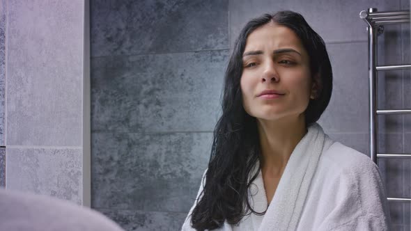 Mixed Race Woman Applying Hair Spray in Bathroom