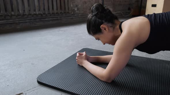 Close - up of a Sporty Young Indian Woman in a Black Top and Leggings Doing a Plank Exercise alt