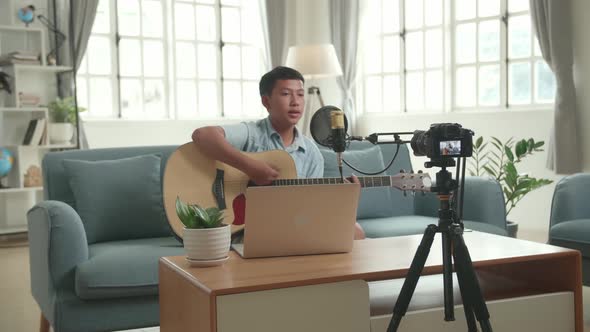 Camera Display With Asian Boy Playing Guitar And Sing A Song While Streaming alt