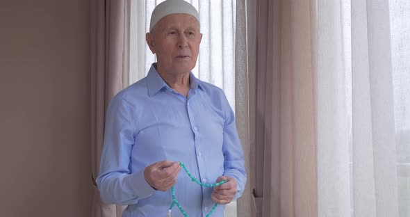 An Old Man with Rosary Beads Praying