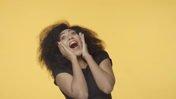 Amazed and Surprised Triumphing Africanamerican Modern Hipster Woman Adult with Afro Hair Screaming alt