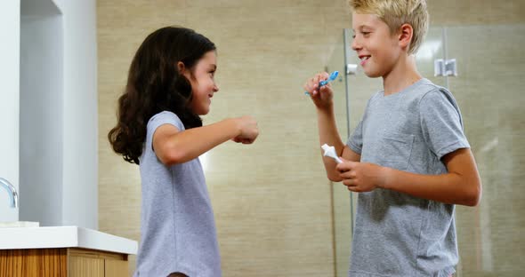 Siblings brushing their teeth in bathroom alt