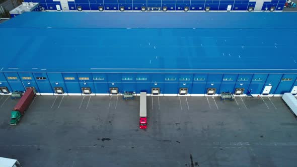 Aerial Top View of the Large Logistics Park with Warehouse with Some Semi-trailers Trucks. alt