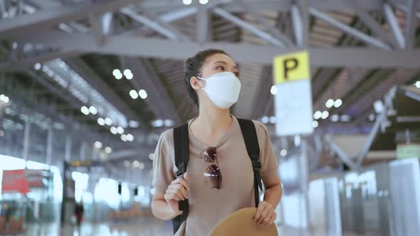 asian female traveller wearing face mask hand use smartphone checking map and flight schedule