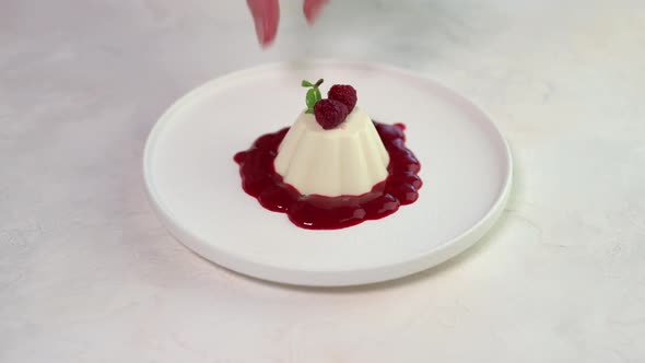 Woman's Hand Lays Mint Leaf to Panna Cotta