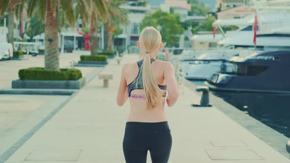 Back View of Fit Girl with Long Blonde Hair Jogging