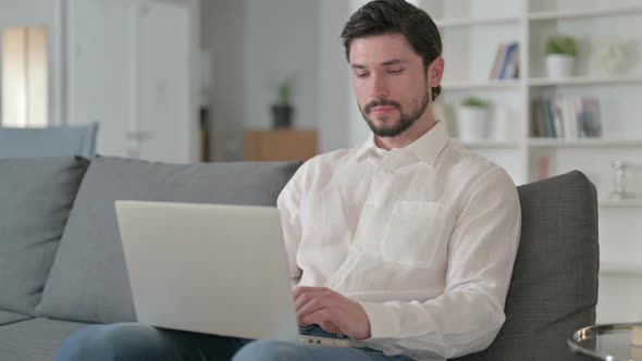 Attractive Young Businessman with Laptop Smiling at the Camera alt
