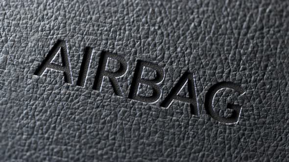 Safety airbag sign in the car's dark leather upholstery. Detailed texture. 4K HD