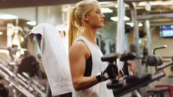 Fit woman exercising with dumbbell alt