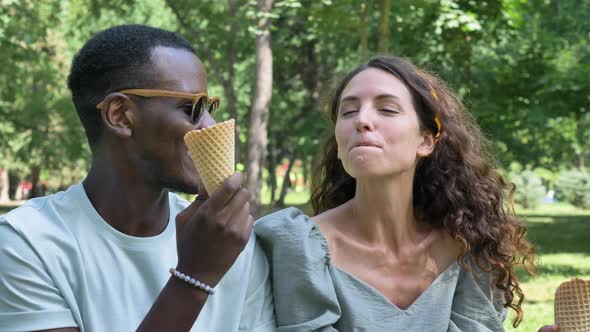 Black Man Treats His Girlfriend to Ice Cream in the Park While Sitting on the Lawn alt