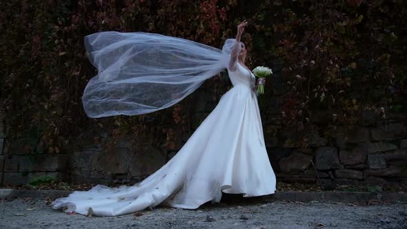 The Bride in a Wedding Dress is Blowing a Strong Wind She is Smiling Sincerely alt