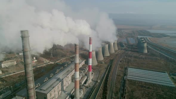 Aerial Drone View of Tall Chimney Pipes with Grey Smoke From Coal Power Plant alt