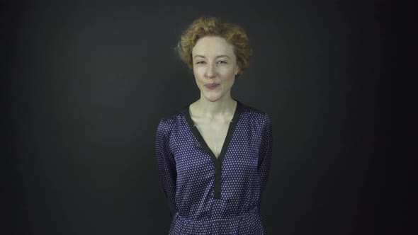 Attractive Lady in Blue Polka Dot Dress Smiles and Winks alt