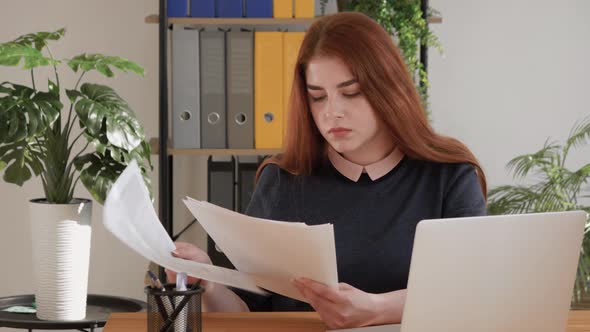 Office worker throwing crumpled paper, having nervous breakdown at work. Angry furious red hair fema alt