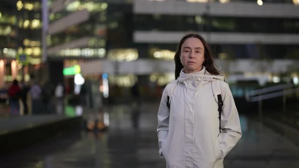 Middleaged Lady is Wearing Casual Street Style Clothes is Walking Alone in Downtown in Evening alt