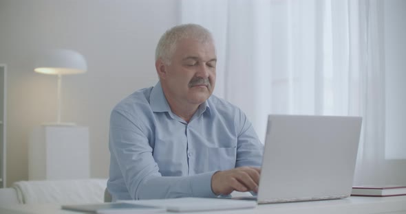 Middle Aged Man with Neck Osteochondrosis Is Working with Laptop, Pain From Overexertion of Muscles alt