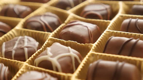 Tilting over gift set of many different candies 4K 2160p 30fps UltraHD footage - Assorted chocolate  alt