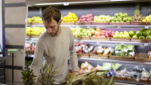 Man Takes a Fresh Fruits From the Food Shelf alt