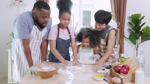 Happy African American family thresh dough together for cookie
