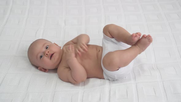 The Newborn Is Lying On The Bed alt