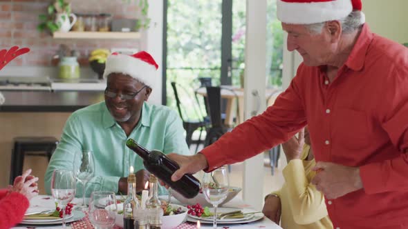 Happy group of diverse senior friends celebrating meal at christmas time alt