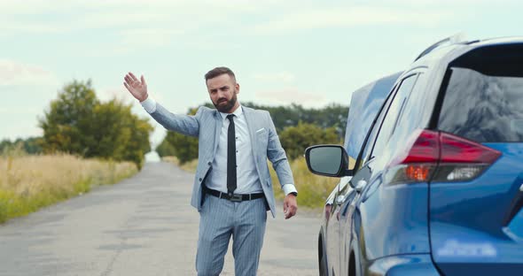 Businessman Standing on Road Near Broken Car and Trying To Catch Help, Countryside Background alt