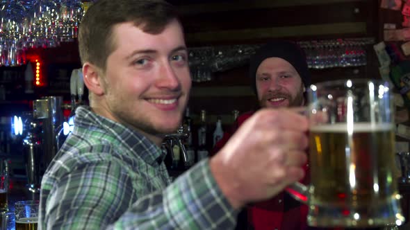 Man Shows a Glass of Beer at the Pub