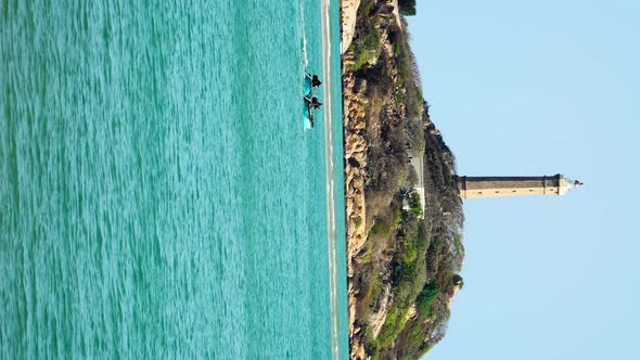 Stunning scene of Ke ga lighthouse, coracle boats in foreground, Vietnam. Vertical alt