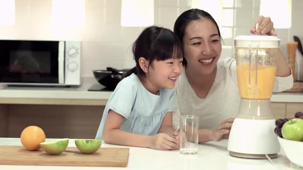 Woman and little girl making smoothie alt