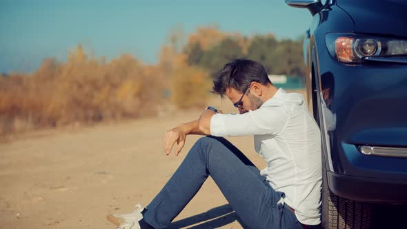 Desperate Businessman Sitting Near Broken Car. Office Burnout Syndrome. After Fired Job. alt