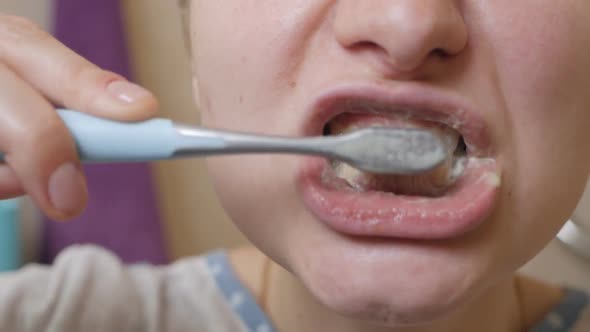 Closeup on Happy Young Woman Brushing Teeth