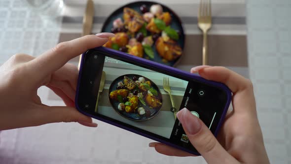 Girl take pictures of grilled peach salad with mozzarella, using smartphone alt